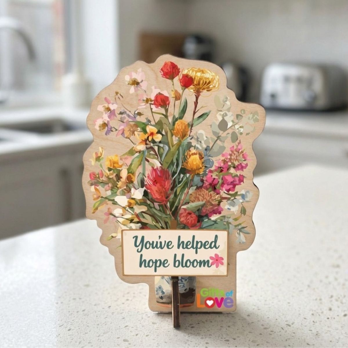 Floral-themed card with 'You've helped hope bloom' message on a kitchen counter.