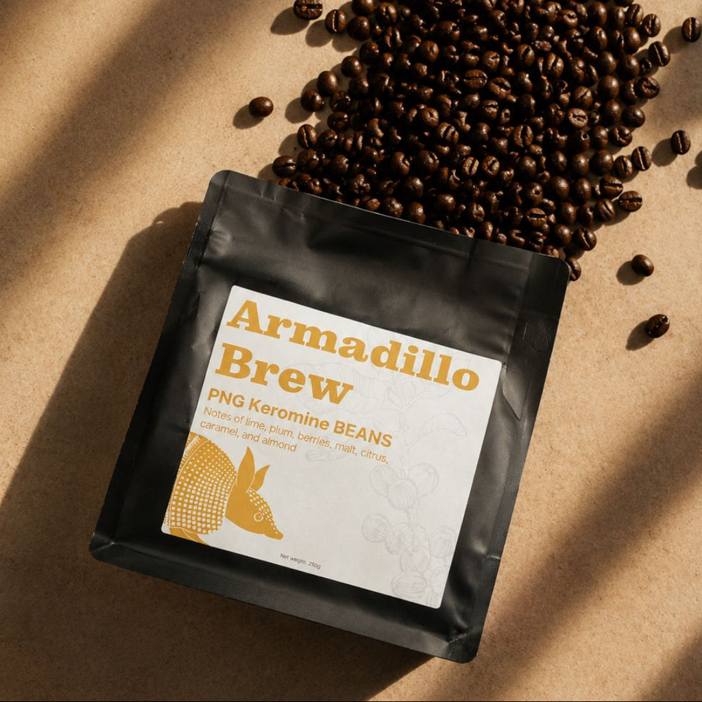 Black coffee bag labeled 'Armadillo Brew' with scattered coffee beans on a brown background