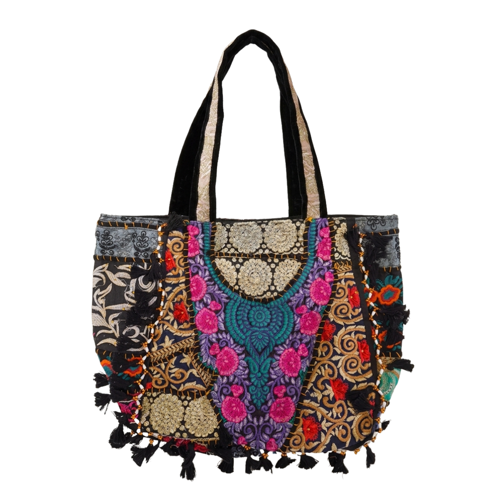 Colorful patchwork handbag with patterns and tassels on a white background