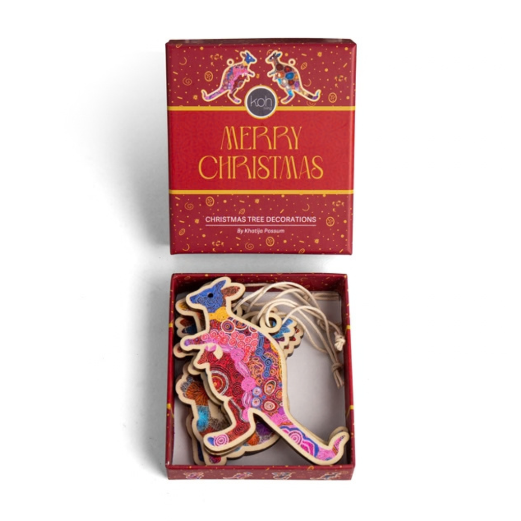 A set of colorful Christmas tree decorations shaped like kangaroos, shown both inside their red gift box and unpacked. The box features gold lettering that reads 'MERRY CHRISTMAS' and illustrations of kangaroos.