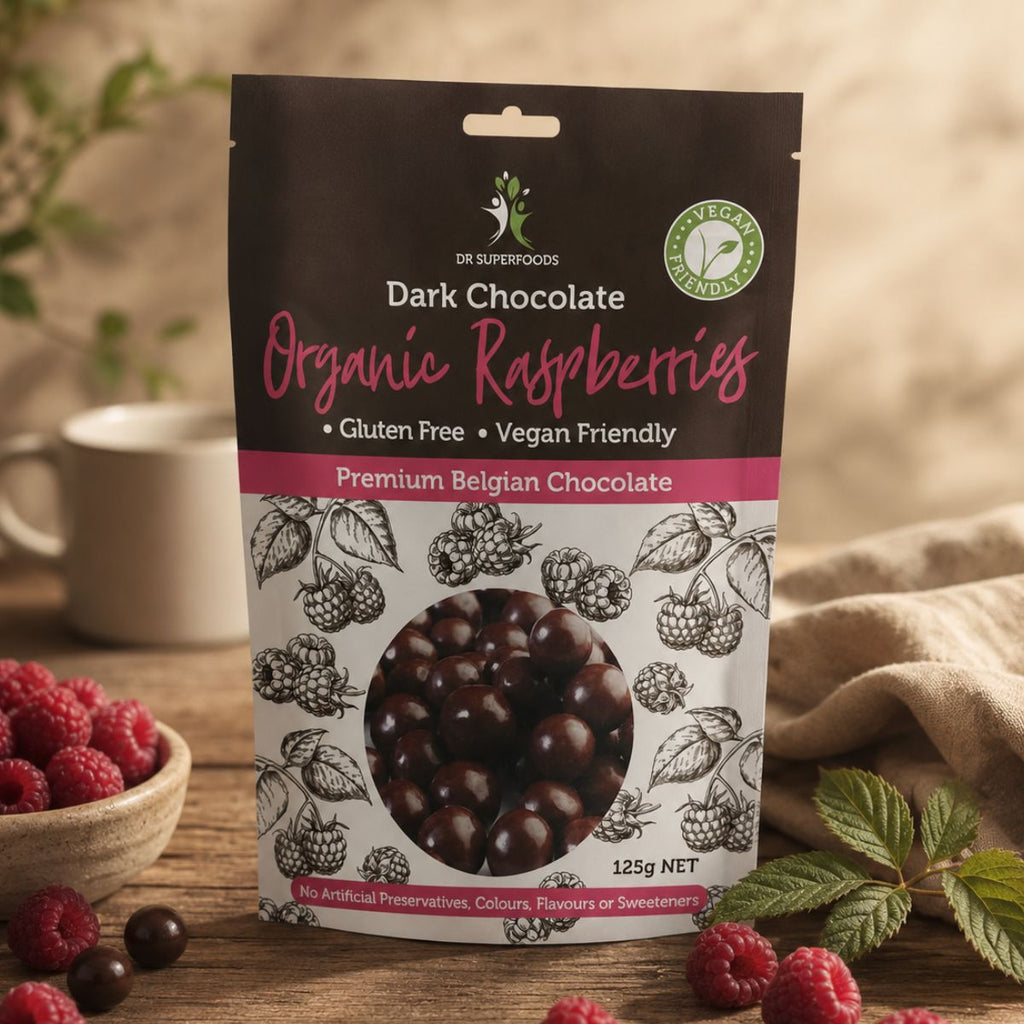 Packaging of dark chocolate organic raspberries with a cup and raspberries on a wooden surface.