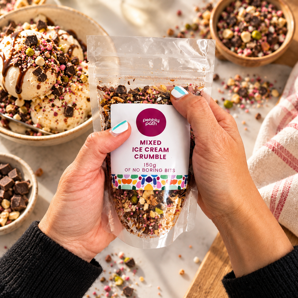 A person holds a clear stand-up pouch of 'Picky Picky' Mixed Ice Cream Crumble. The packaging features a white label with a purple logo and colorful illustrations.