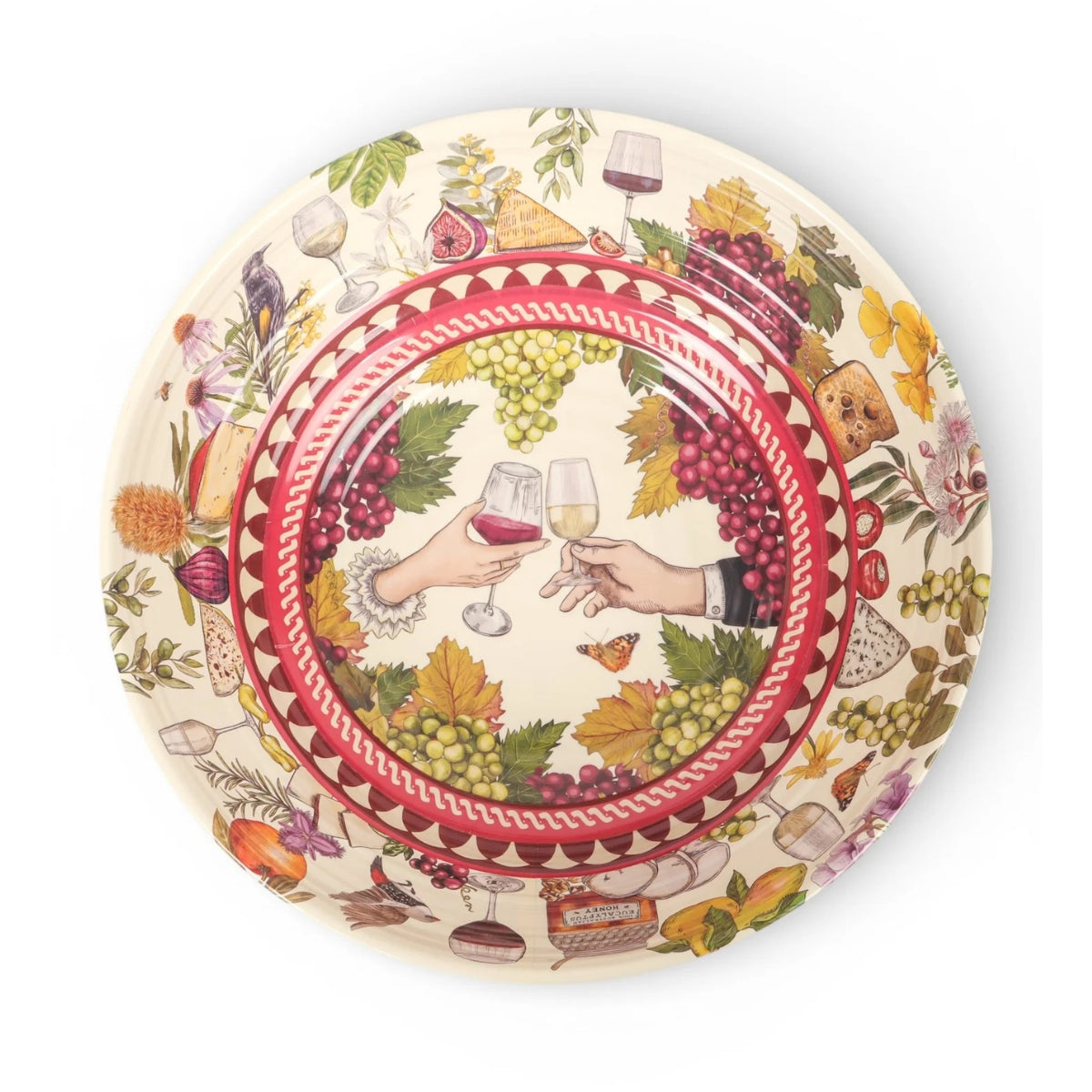 A round ceramic serving platter featuring an intricate wine-themed illustration with two hands clinking wine glasses, surrounded by grapes, wine bottles, cheese, and leaves on a cream background.
