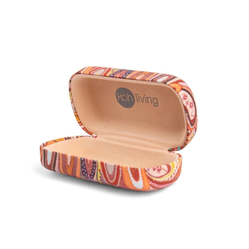 An open hard-shell glasses case with a colorful paisley pattern in orange, red, brown, and white, featuring a tan interior and the 'koh living' logo printed inside the lid, set against a plain white background.