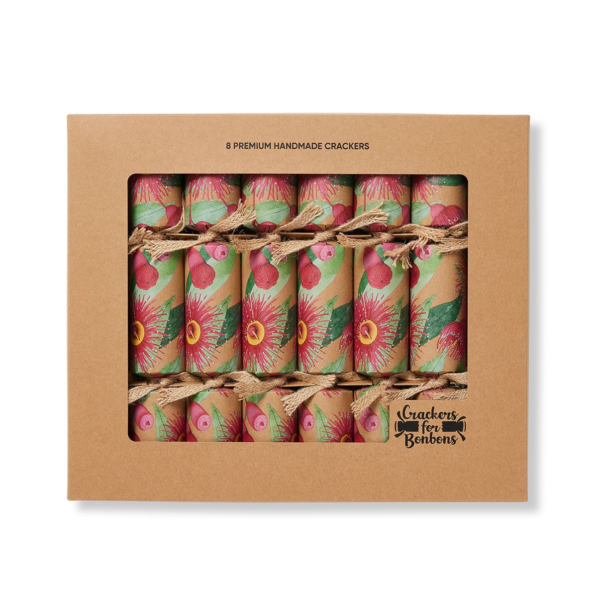 A kraft paper gift box containing eight decorated handmade crackers. The crackers are wrapped in brown kraft paper with a colorful floral pattern featuring pink, red, and green, and are tied with jute twine.