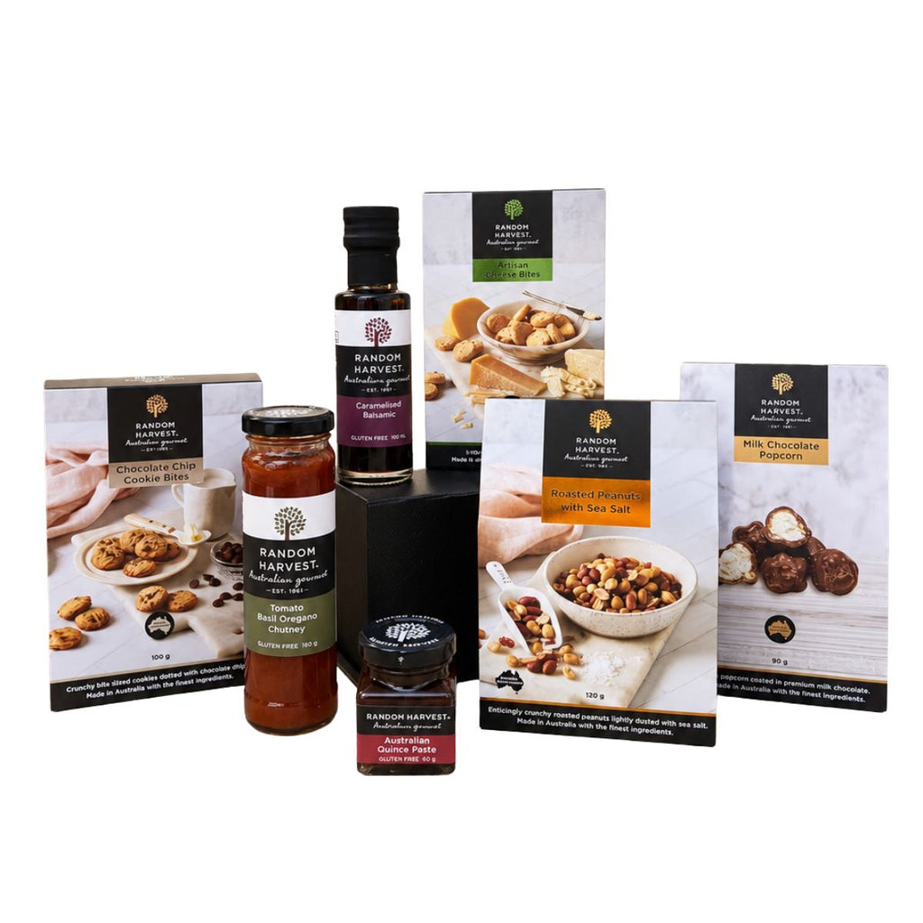 A curated food gift set from Random Harvest, featuring packaged items including a jar of chutney, a bottle of sea salt, and boxes of chocolate and nut spreads on a clean white background.
