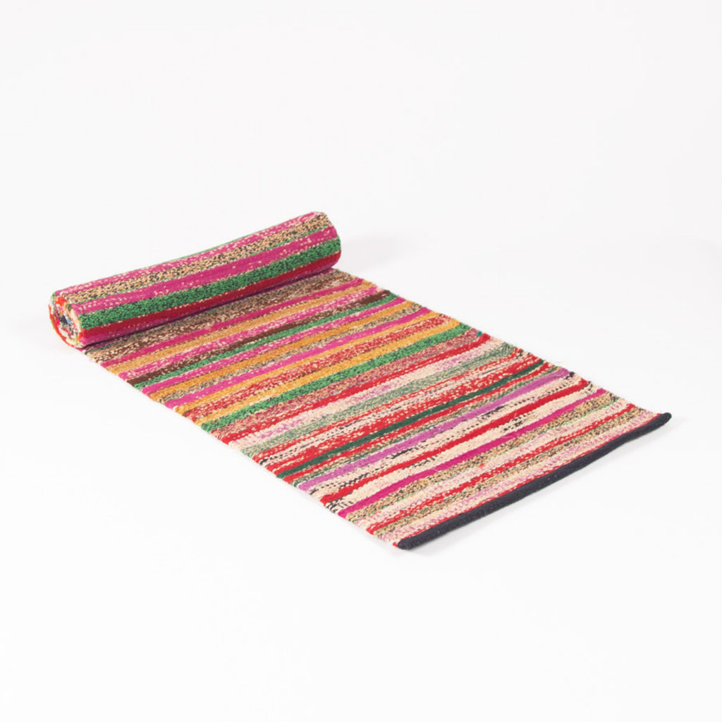 A multicolor striped runner rug with a textured, woven appearance, shown partially unrolled on a clean white background.
