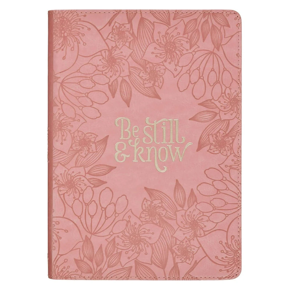 A pink journal with an embossed floral pattern and the words 'Be still & know' in a light gold metallic font on the front cover, shown against a plain white background.
