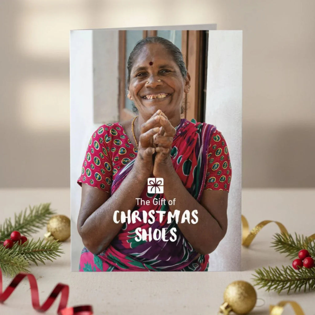 Card with a woman smiling and text 'The Gift of Christmas Shoes' surrounded by Christmas decorations.