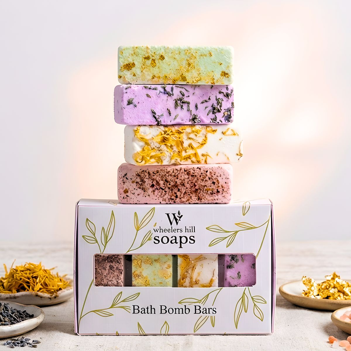 Stack of bath bomb bars with a 'Wheeler Hill Soaps' box on a light background