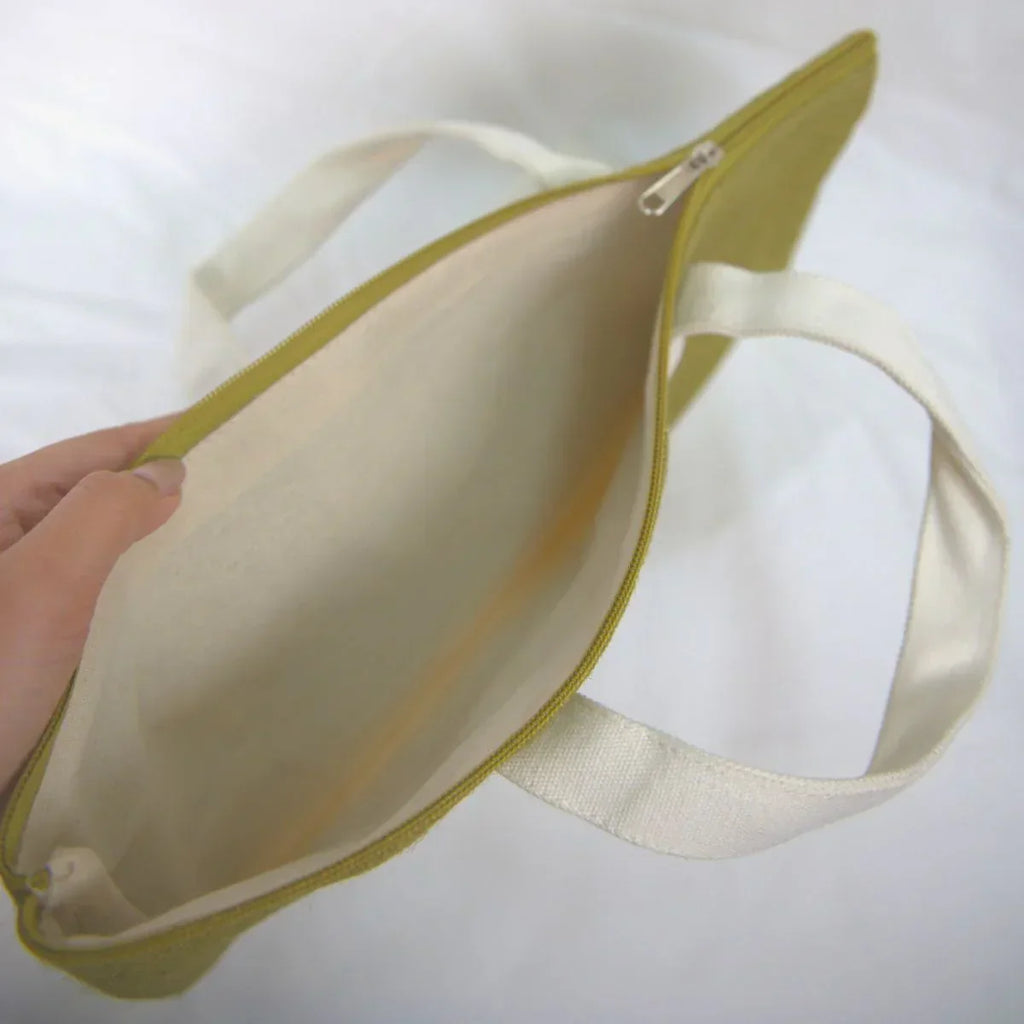 Beige pouch with a strap held by a hand on a white background