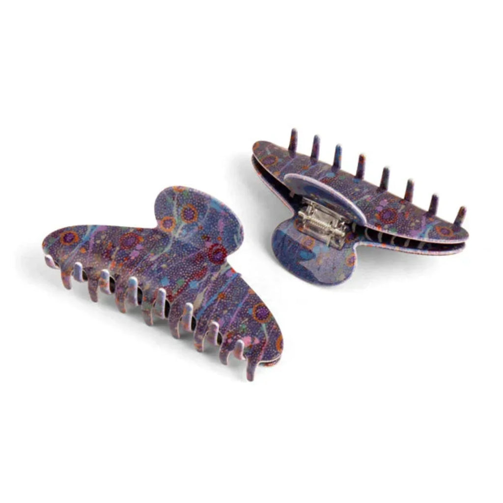 Pair of decorative hair clips with intricate patterns on a white background