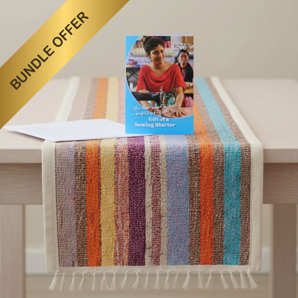 Colorful striped towel on a table with a book titled 'Girl at a Sewing Machine' and 'Bundle Offer' text.