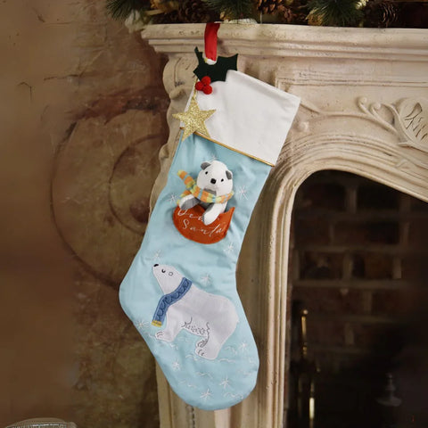 Christmas stocking with polar bear design hanging on a fireplace mantle.